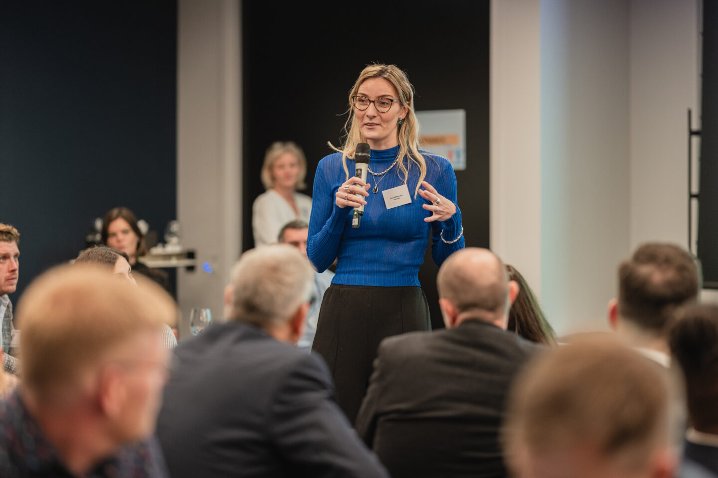 A delegate holding a microphone addressing a room of people