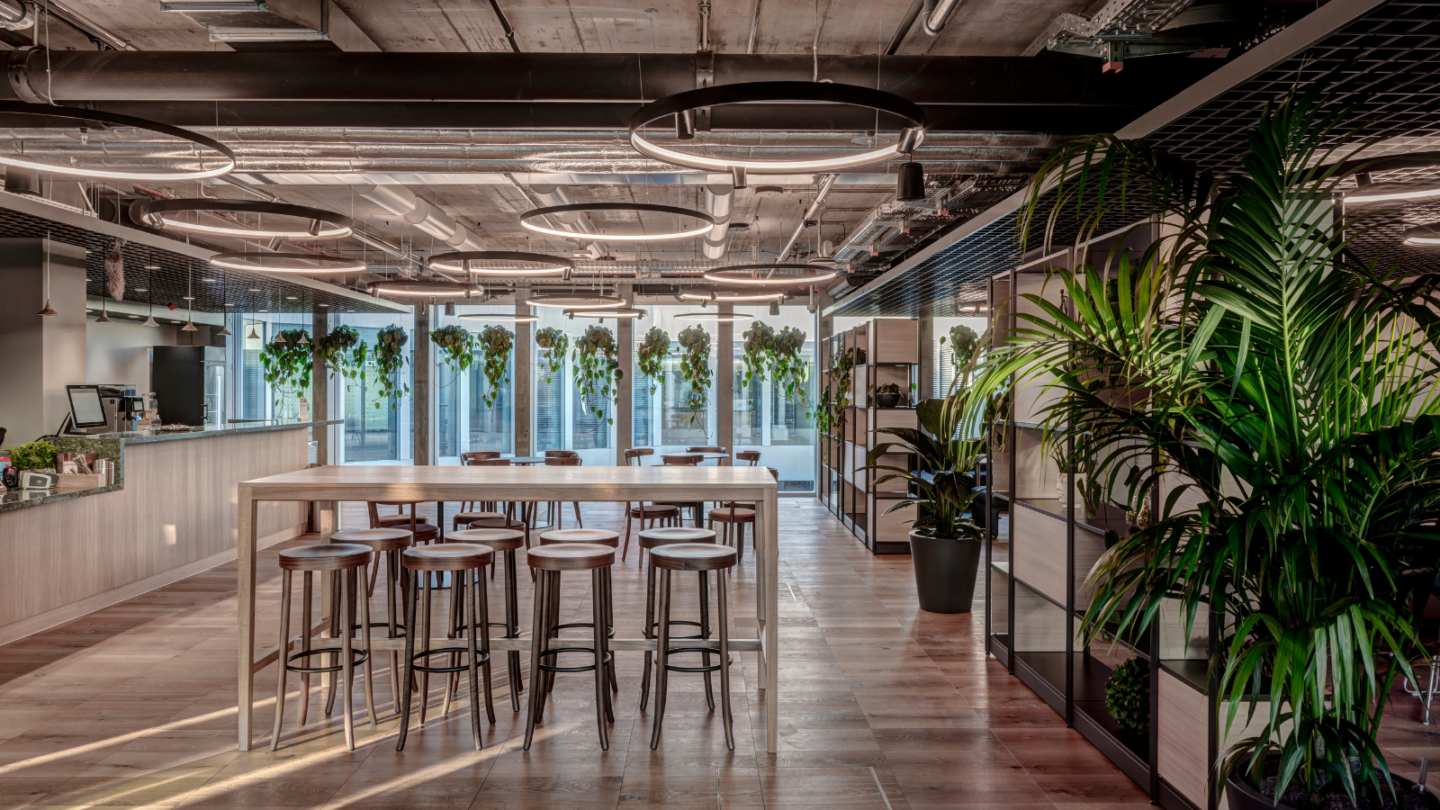 Microsoft Zurich office space with plants, circular lights and a high top table in the center