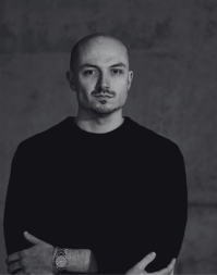 An adult male wearing a dark coloured crew neck.