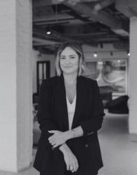 A fair haired woman with shoulder length hair wearing a dark blazer