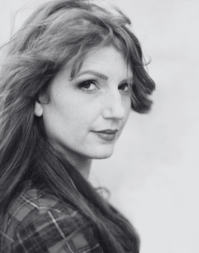 A side profile of a woman with long hair wearing a tartan jacket