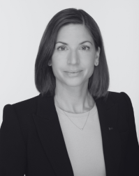 A smartly dressed business woman with shoulder length dark hair.