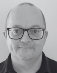 An adult white mail wearing a dark top and glasses.