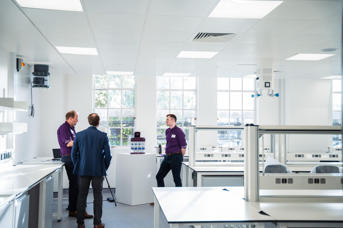 Three people standing in a lab situated in Victoria House, London