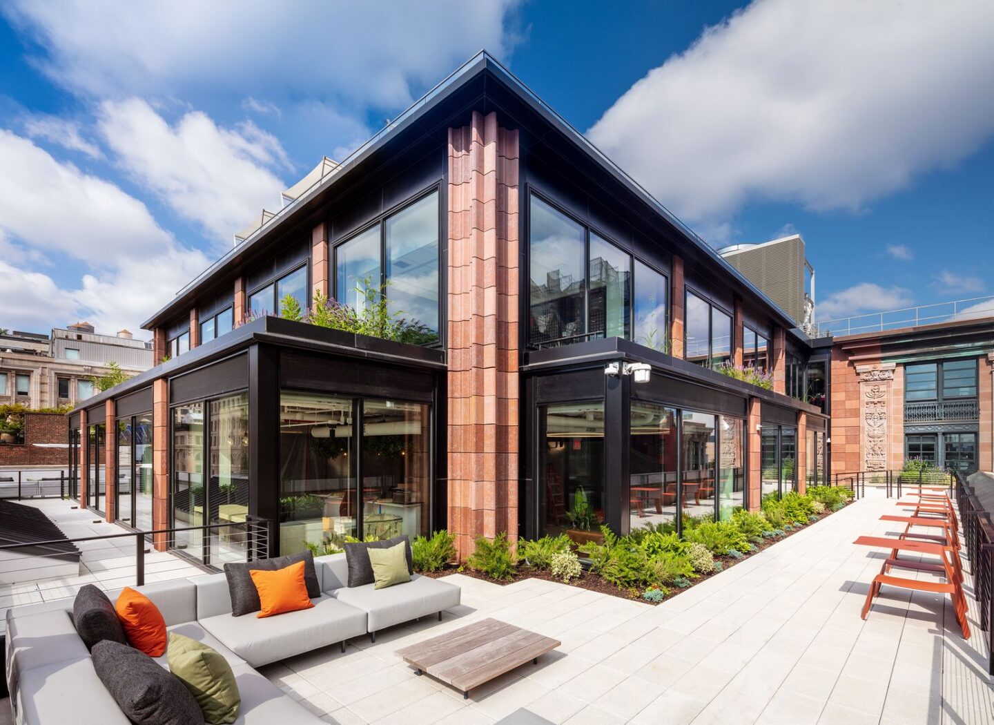 External view of Mastercard NYC Tech hub's rooftop terrace with soft seating and blue skies in the background